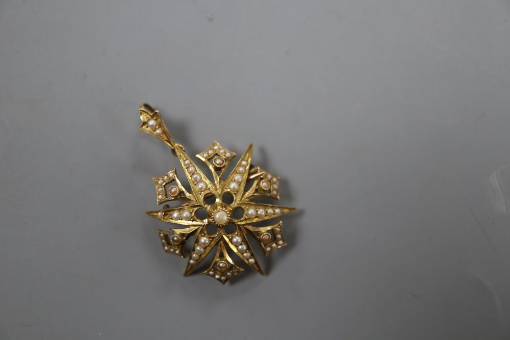 An Edwardian 15ct and graduated seed pearl set starburst pendant brooch, 32mm, gross 6.4 grams.